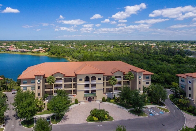 drone / aerial view featuring a water view and a view of trees