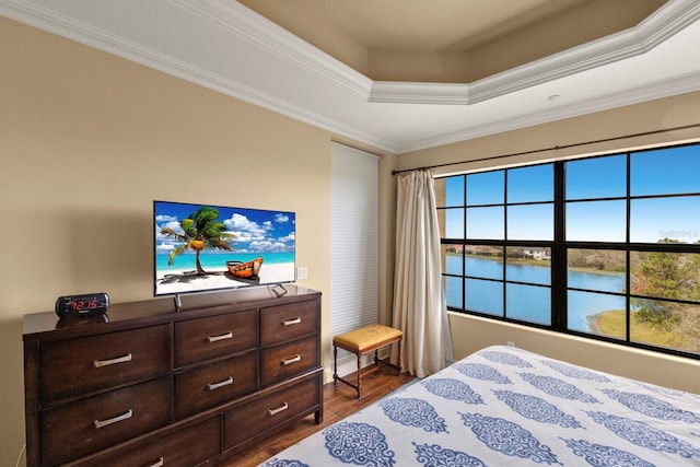 bedroom featuring dark wood-style floors, a tray ceiling, and ornamental molding