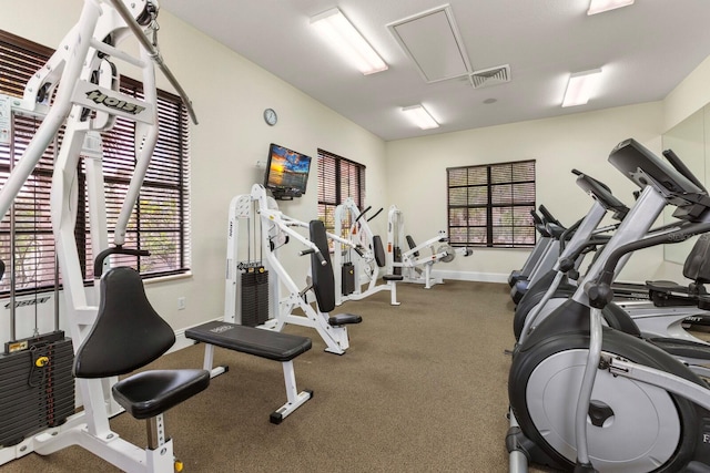 exercise room featuring visible vents, baseboards, and attic access