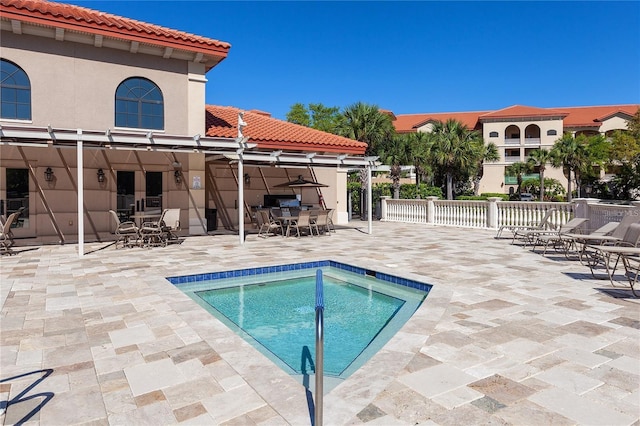 view of swimming pool with a patio area, outdoor dining area, and fence