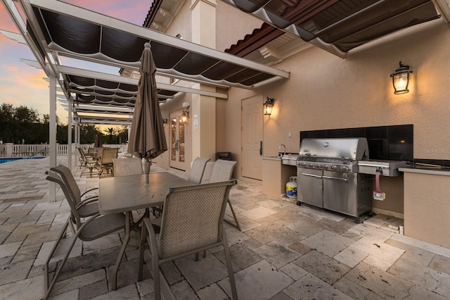 view of patio featuring outdoor dining space, area for grilling, and fence
