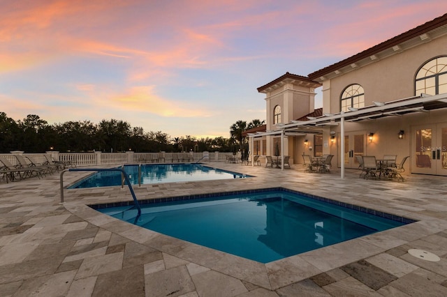 view of pool with french doors, a patio, a fenced in pool, and fence