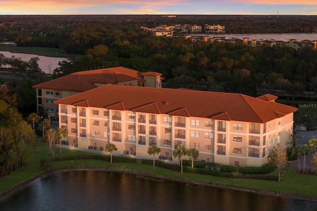 aerial view at dusk featuring a water view