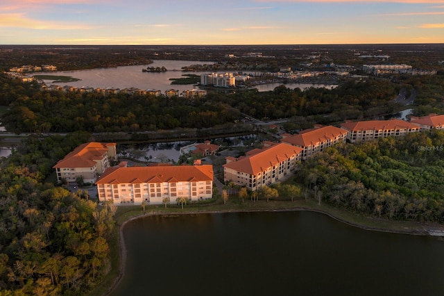 aerial view at dusk featuring a water view