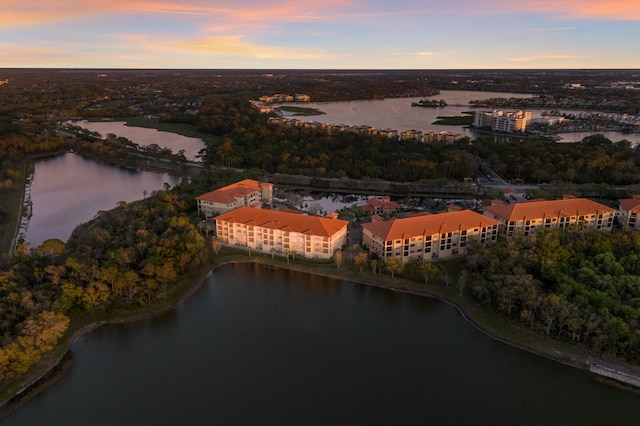 aerial view at dusk featuring a water view