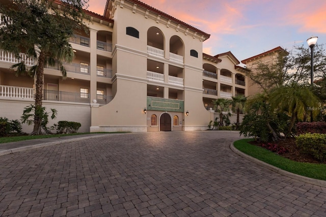 property at dusk with curved driveway