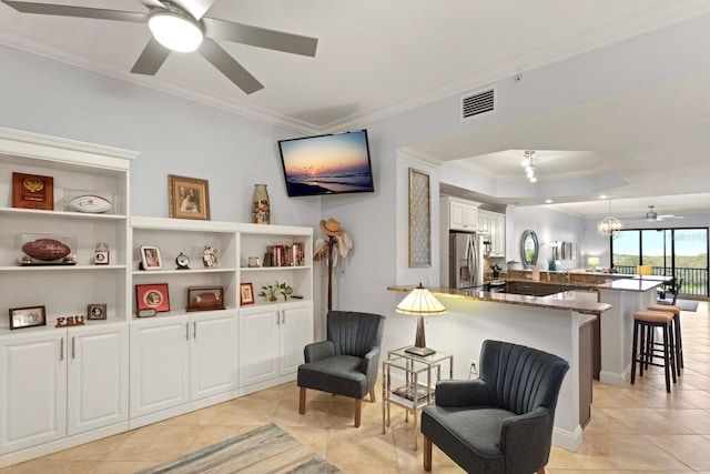 living area featuring visible vents, a ceiling fan, and ornamental molding