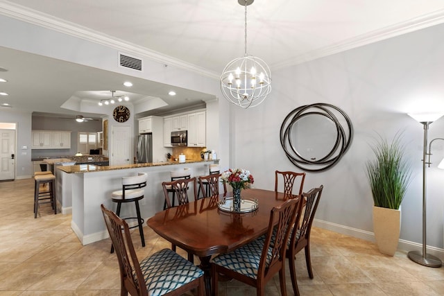 dining area with a tray ceiling, baseboards, visible vents, and ornamental molding