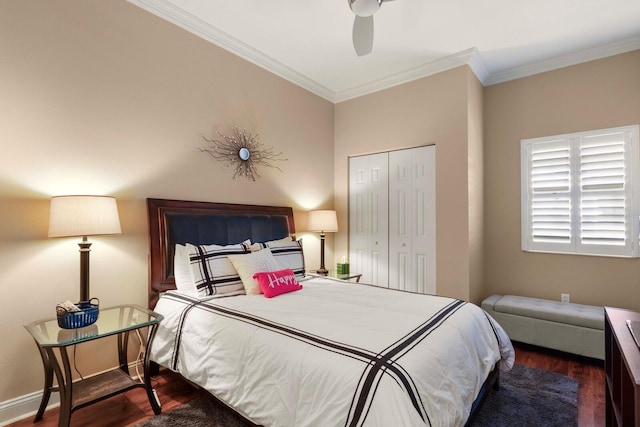bedroom with a closet, ornamental molding, baseboards, and wood finished floors