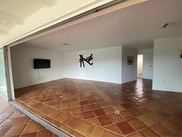 tiled spare room featuring visible vents