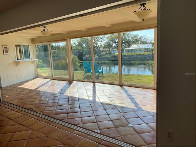 unfurnished sunroom featuring plenty of natural light and a water view