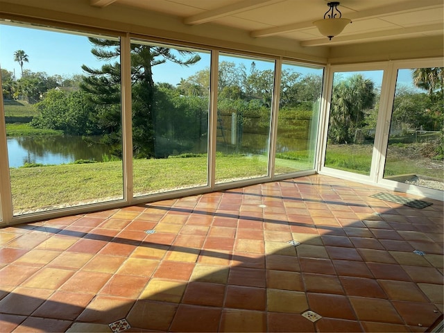 unfurnished sunroom featuring a water view and beam ceiling