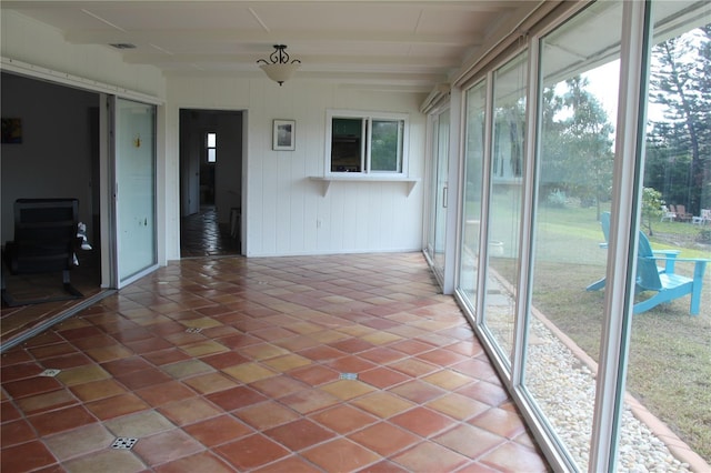 unfurnished sunroom with visible vents and beam ceiling