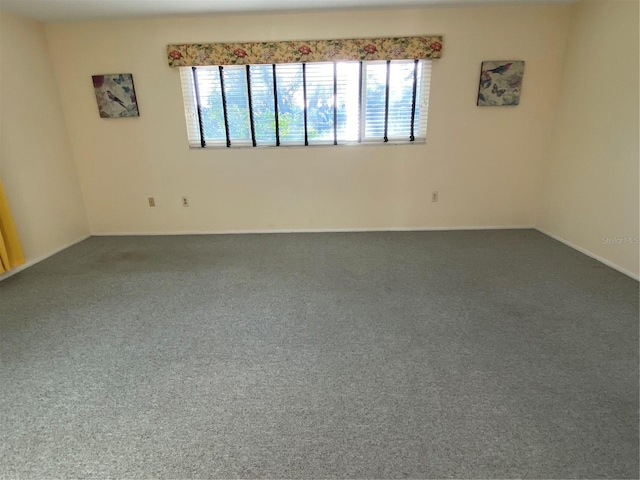 unfurnished room featuring dark colored carpet