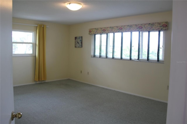 carpeted empty room featuring baseboards