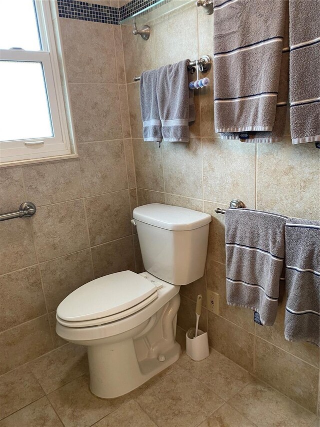 bathroom featuring tile patterned flooring, radiator, tile walls, and toilet