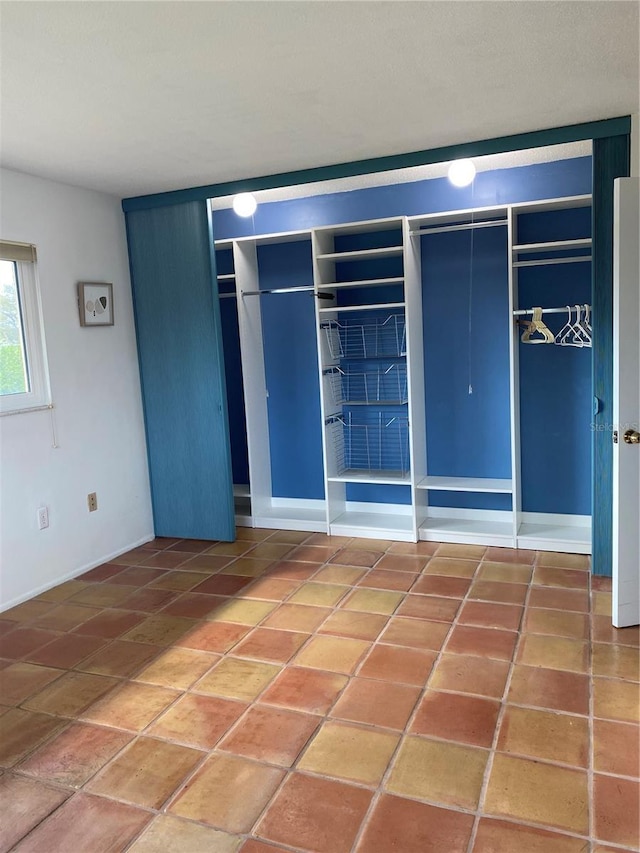 unfurnished bedroom with tile patterned flooring and two closets