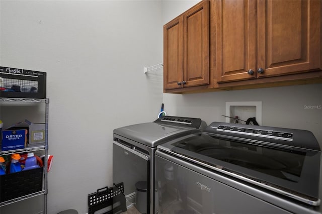 washroom featuring cabinet space and washing machine and dryer