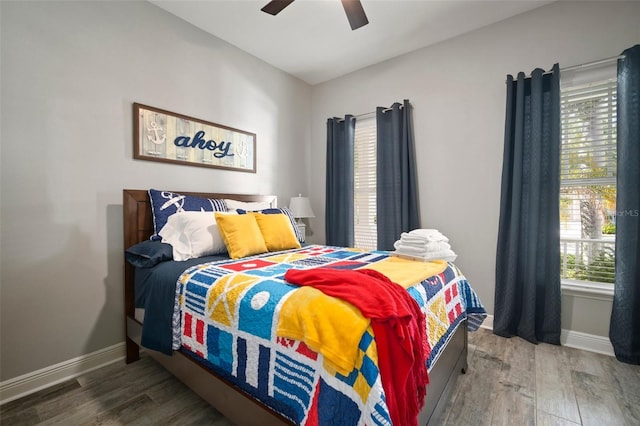 bedroom with ceiling fan, baseboards, and wood finished floors