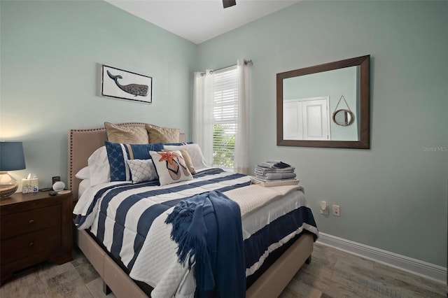 bedroom with a ceiling fan, wood finished floors, and baseboards