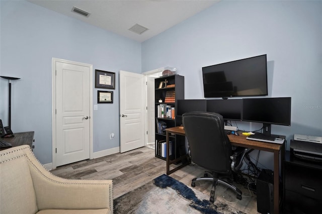 office space featuring visible vents, baseboards, and wood finished floors