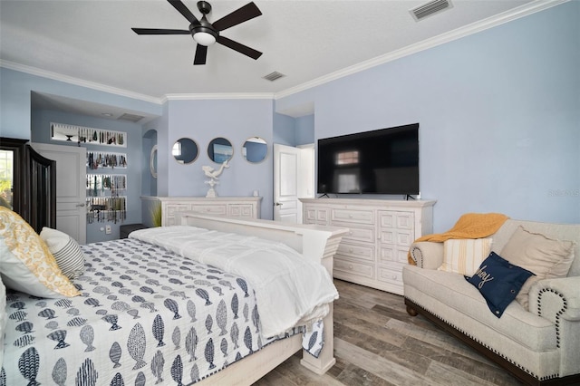 bedroom with visible vents, crown molding, ceiling fan, and wood finished floors