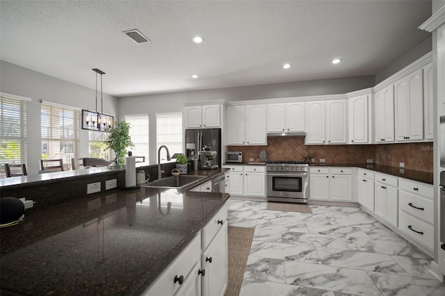 kitchen with visible vents, backsplash, marble finish floor, stainless steel appliances, and a sink