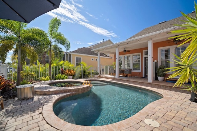 view of swimming pool featuring a patio, a pool with connected hot tub, a ceiling fan, and fence