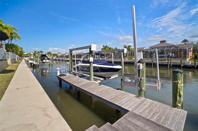 dock area featuring boat lift, a residential view, and a water view