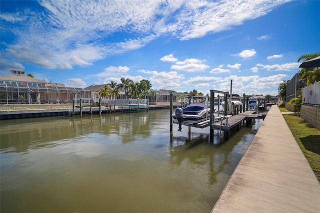 dock area with a residential view, boat lift, and a water view