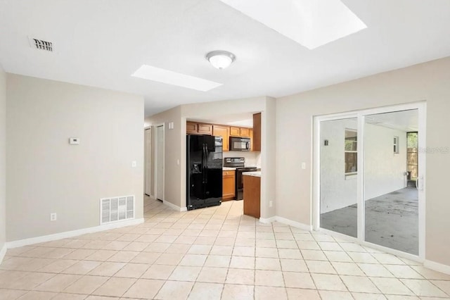 kitchen featuring black appliances, a skylight, visible vents, and light countertops