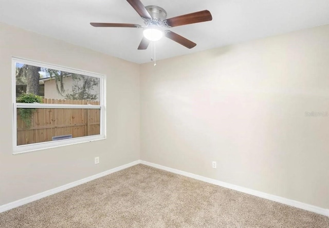 unfurnished room featuring carpet floors, ceiling fan, and baseboards