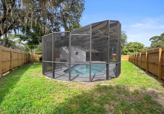 view of swimming pool featuring a lanai, a fenced backyard, a fenced in pool, and a lawn