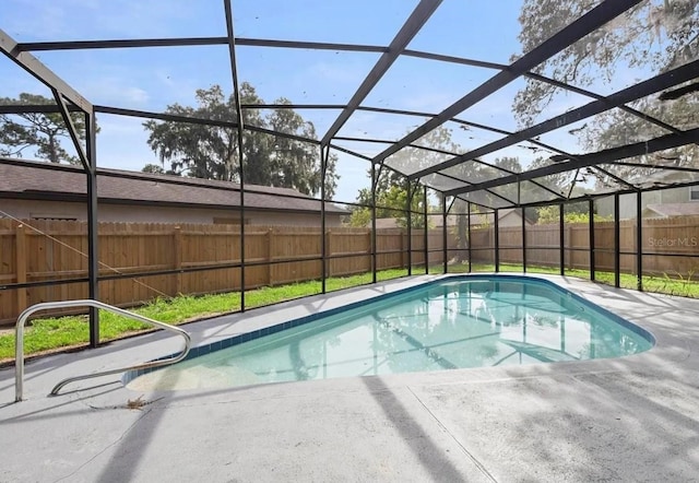 view of swimming pool with glass enclosure, a fenced backyard, and a fenced in pool