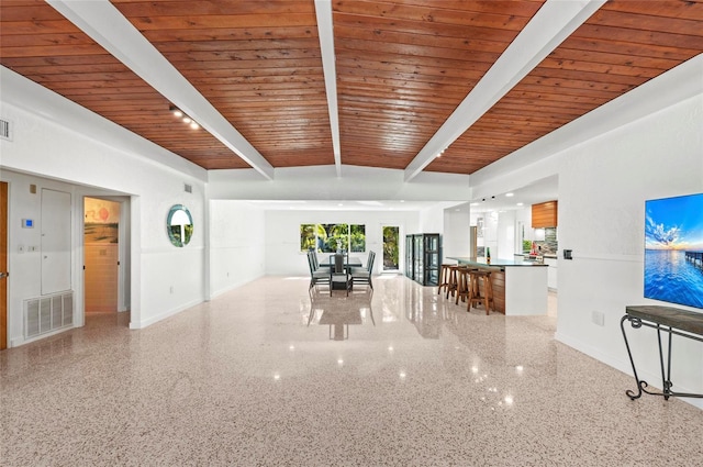 unfurnished living room with light speckled floor, wood ceiling, beam ceiling, and visible vents