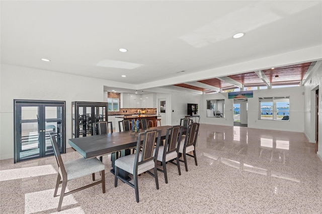 dining area with recessed lighting, beamed ceiling, baseboards, and speckled floor