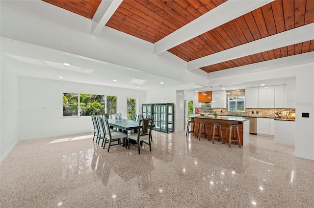 dining area featuring wood ceiling, beamed ceiling, and baseboards