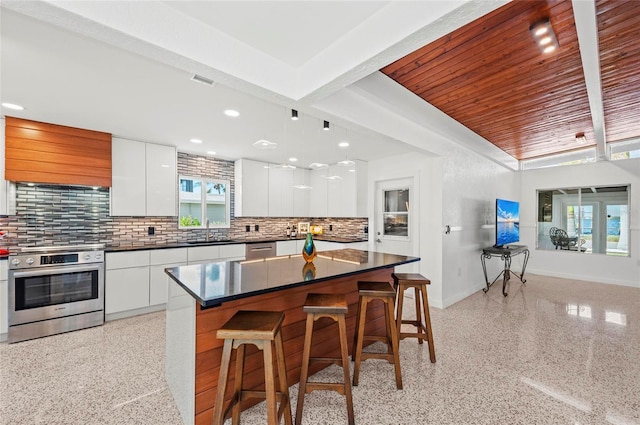 kitchen featuring stainless steel appliances, a sink, light speckled floor, and modern cabinets