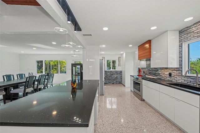 kitchen featuring stainless steel electric range, a sink, white cabinets, and modern cabinets