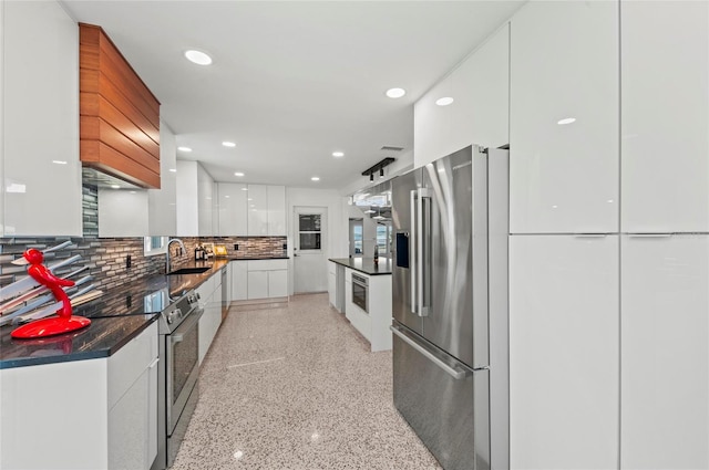 kitchen featuring tasteful backsplash, white cabinets, dark countertops, modern cabinets, and stainless steel appliances