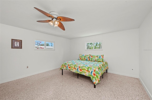 bedroom with a ceiling fan, multiple windows, baseboards, and speckled floor