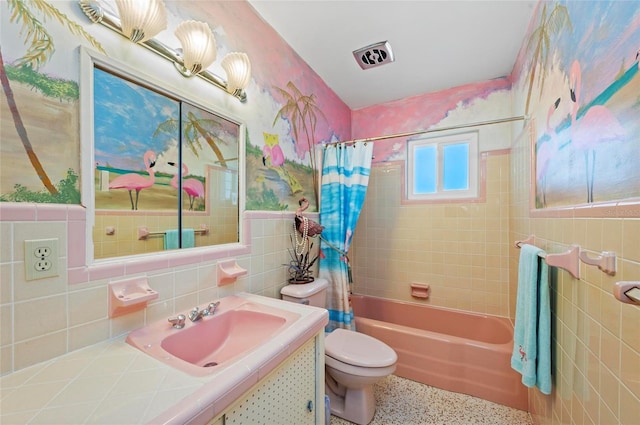 bathroom featuring shower / tub combo with curtain, tile walls, toilet, vanity, and speckled floor