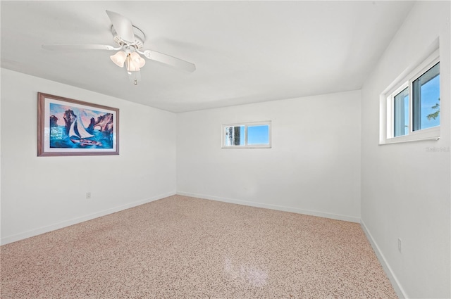 empty room featuring ceiling fan and baseboards