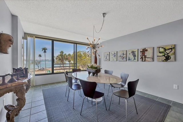 dining room featuring tile patterned flooring, a textured ceiling, and a notable chandelier