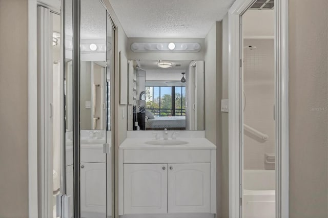 ensuite bathroom featuring a textured ceiling, vanity, a shower, ensuite bath, and a bathtub