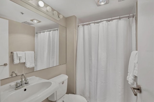 full bathroom with visible vents, curtained shower, a sink, and toilet