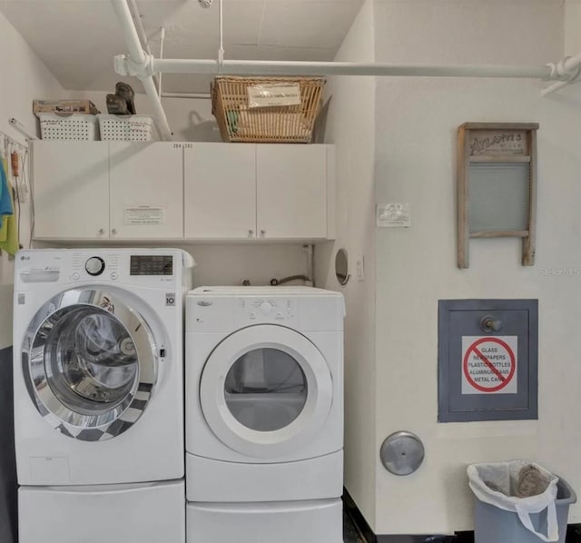 clothes washing area featuring cabinet space and washer and dryer