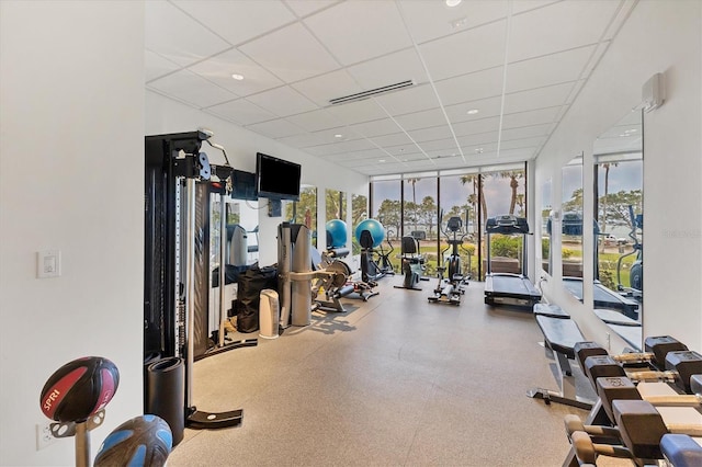 gym featuring expansive windows, visible vents, and a drop ceiling