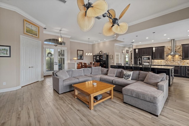 living area with light wood-type flooring, baseboards, ornamental molding, and recessed lighting