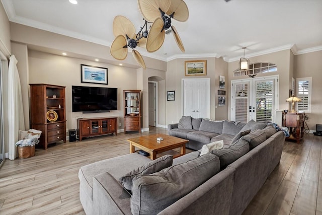 living area featuring arched walkways, wood finished floors, baseboards, french doors, and crown molding